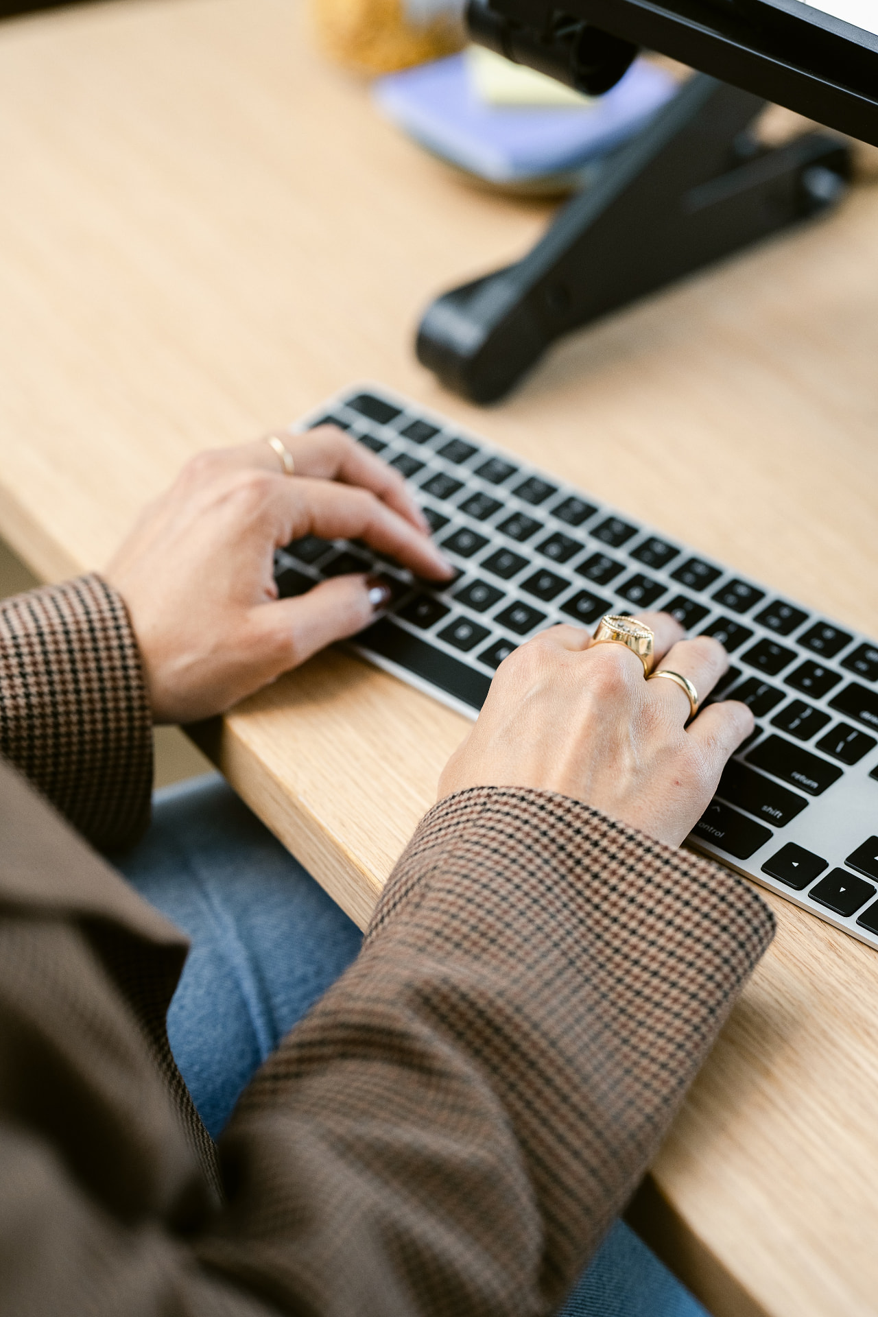 Jess typing at a wooden desk